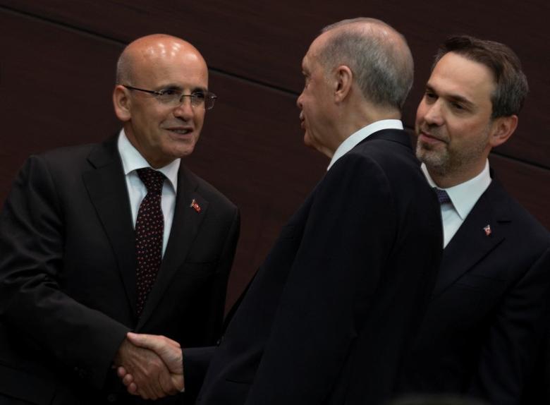 turkish president recep tayyip erdogan shakes hands with the new treasury and finance minister mehmet simsek left in ankara on june 3